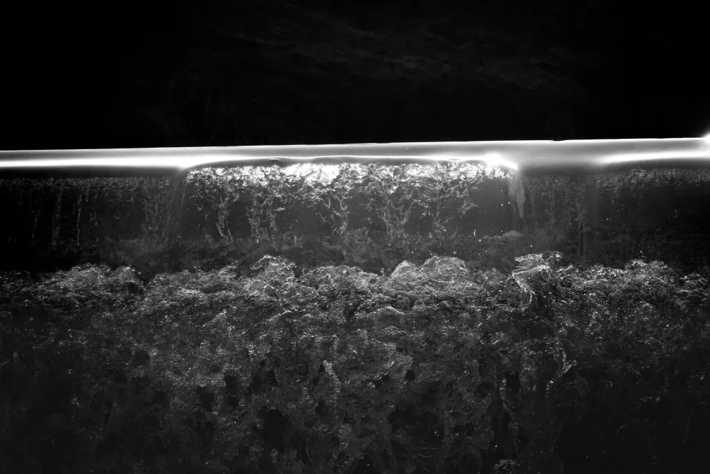 Water raging over the weir at Linn Jaw Waterfall. Black and white